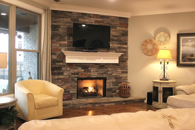 living room featuring ornamental molding, wood-type flooring, and a fireplace