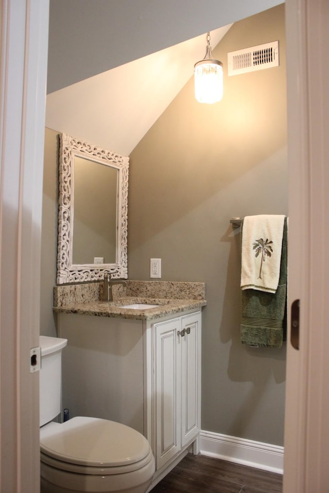 bathroom with wood-type flooring, toilet, and vanity