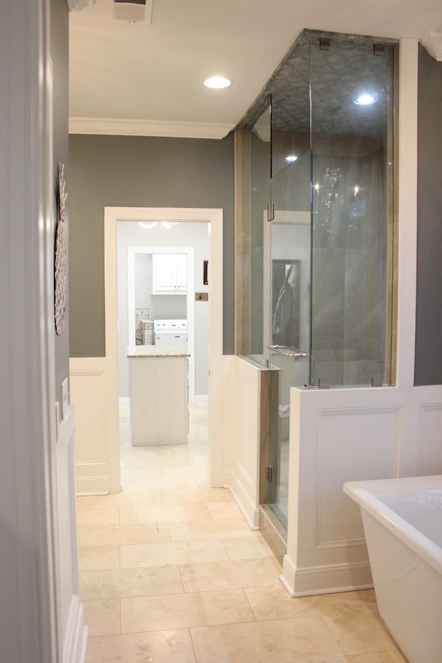 bathroom featuring ornamental molding and shower with separate bathtub