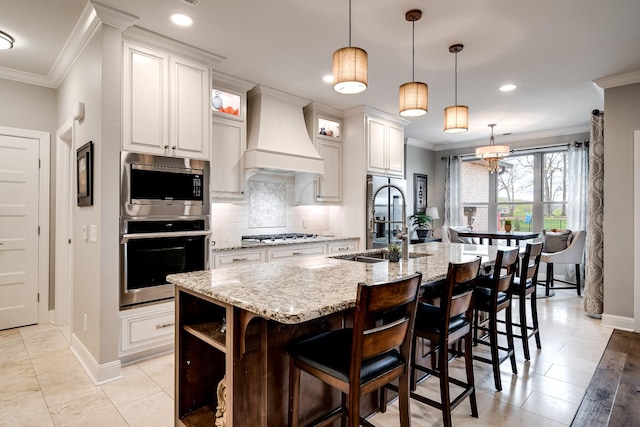 4888 Rock House Rd, Portland, TN 37148 - kitchen featuring tasteful backsplash, ornamental molding, a kitchen island with sink, a sink, and custom range hood