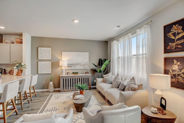 living room with radiator and light hardwood / wood-style flooring