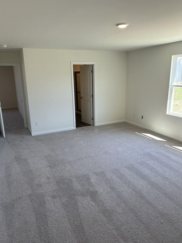 carpeted spare room with baseboards