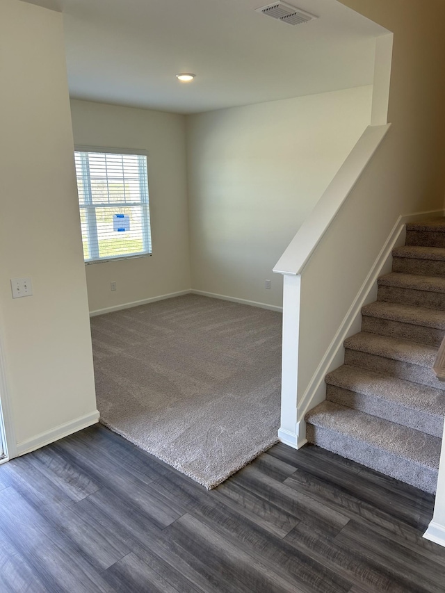 interior space with baseboards, visible vents, carpet, and wood finished floors