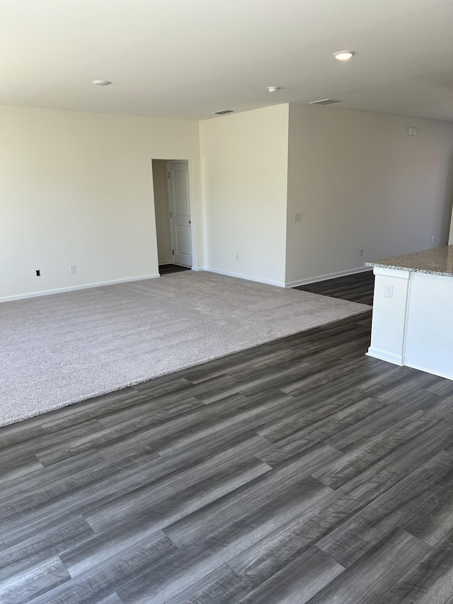 empty room featuring dark wood-style floors, baseboards, and recessed lighting