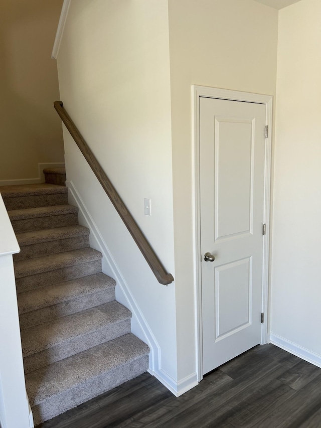staircase featuring baseboards and wood finished floors