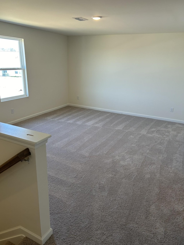 carpeted empty room with baseboards and visible vents