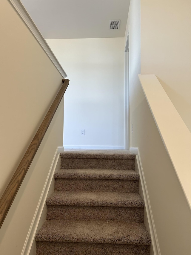 staircase with baseboards and visible vents