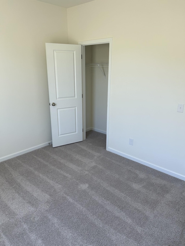 unfurnished bedroom featuring carpet flooring, a closet, and baseboards