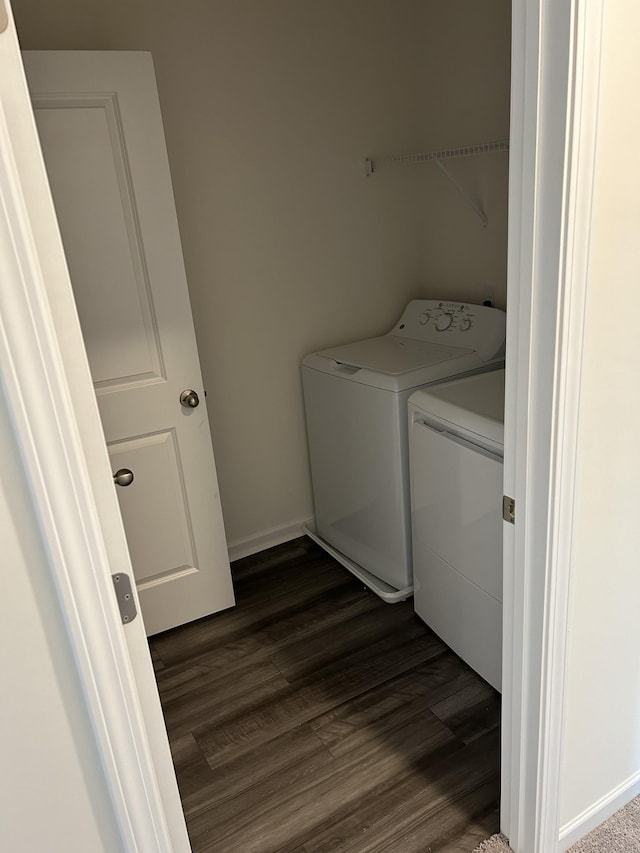 clothes washing area featuring baseboards, washer and dryer, laundry area, and dark wood-style flooring