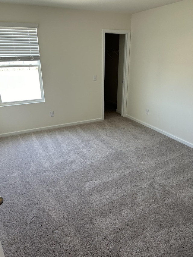carpeted spare room featuring baseboards