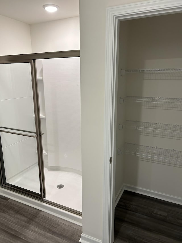 bathroom featuring wood finished floors and a stall shower