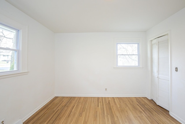 unfurnished bedroom with a closet and light wood-type flooring