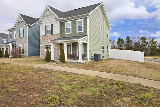 view of front of property featuring a porch, a front yard, and cooling unit