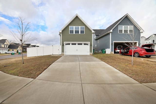 traditional-style home featuring a garage, concrete driveway, a front lawn, and fence