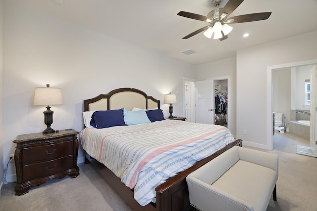 bedroom with a closet, light colored carpet, visible vents, a spacious closet, and baseboards