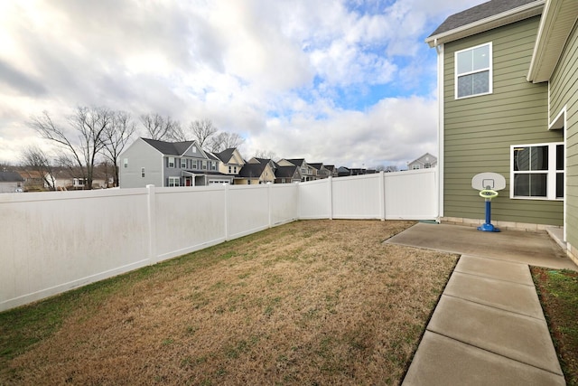 view of yard featuring a residential view, a patio area, and a fenced backyard