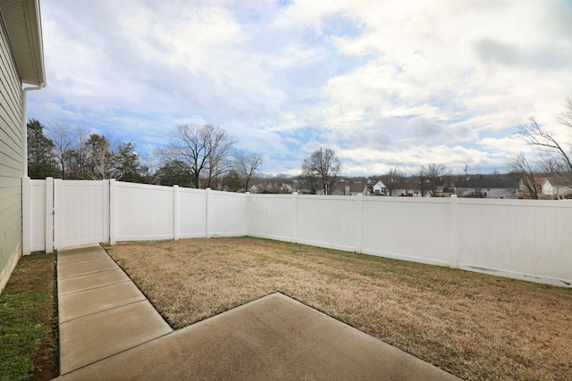 view of yard featuring a patio, a fenced backyard, and a gate