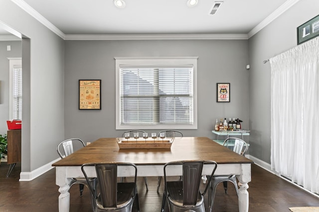 dining area with ornamental molding and dark hardwood / wood-style floors