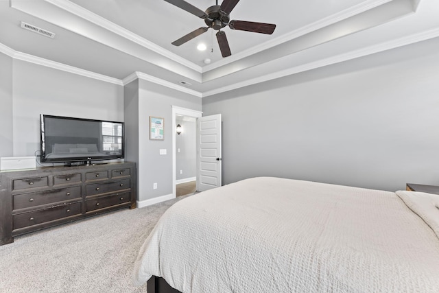 bedroom featuring a raised ceiling, ornamental molding, light colored carpet, and ceiling fan