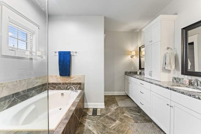 bathroom with vanity and tiled tub