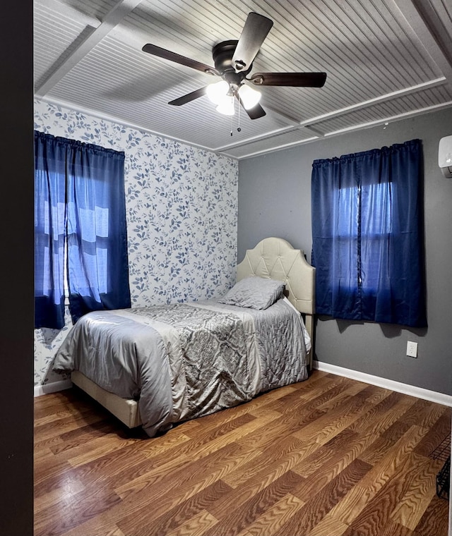 bedroom featuring hardwood / wood-style flooring, an AC wall unit, and ceiling fan