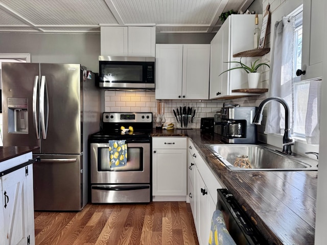 kitchen featuring appliances with stainless steel finishes, sink, white cabinets, and dark hardwood / wood-style floors