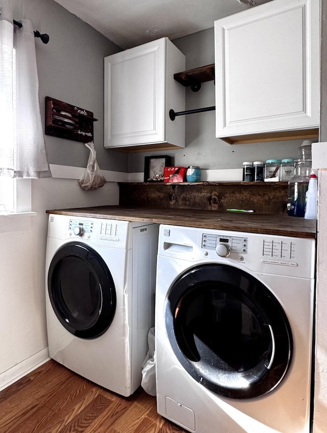 laundry area featuring cabinets, separate washer and dryer, and dark hardwood / wood-style flooring