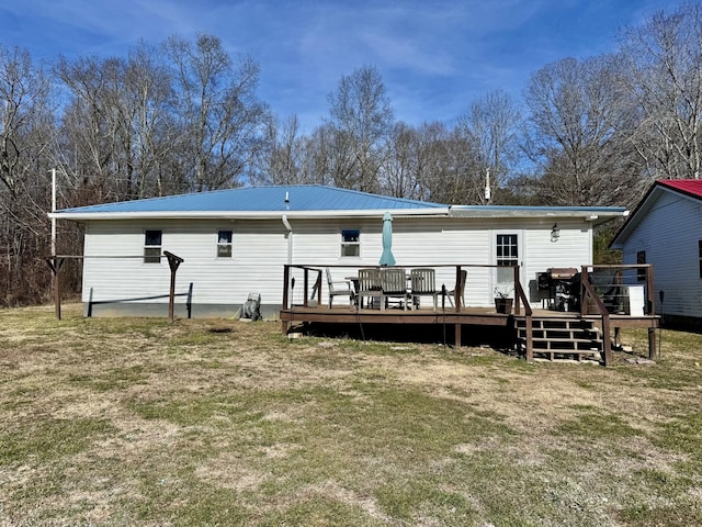 rear view of house with a wooden deck and a yard