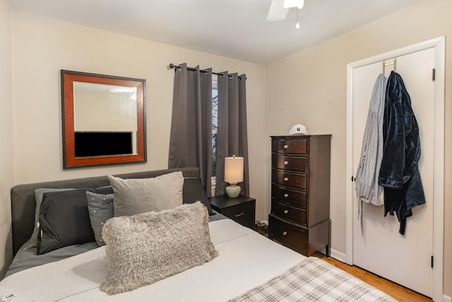 bedroom with hardwood / wood-style floors, ceiling fan, and a closet