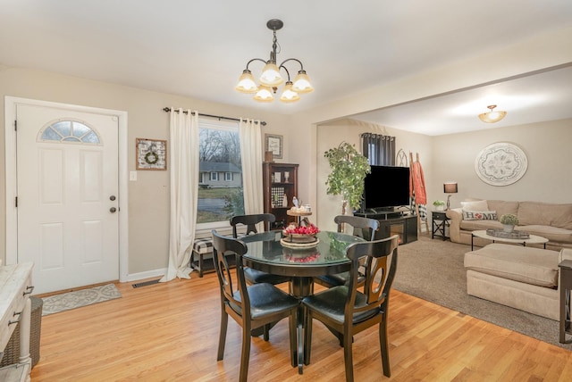 dining space featuring an inviting chandelier and light hardwood / wood-style flooring