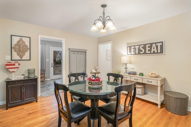 dining area featuring a notable chandelier and light hardwood / wood-style flooring