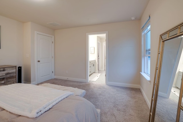 carpeted bedroom featuring multiple windows and ensuite bath