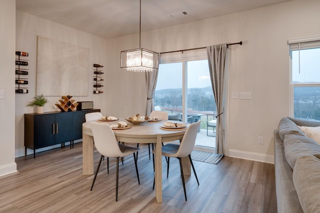 dining space with a mountain view, wood-type flooring, and a healthy amount of sunlight