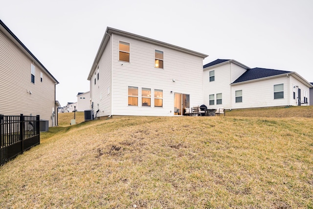 rear view of house with a yard and central AC