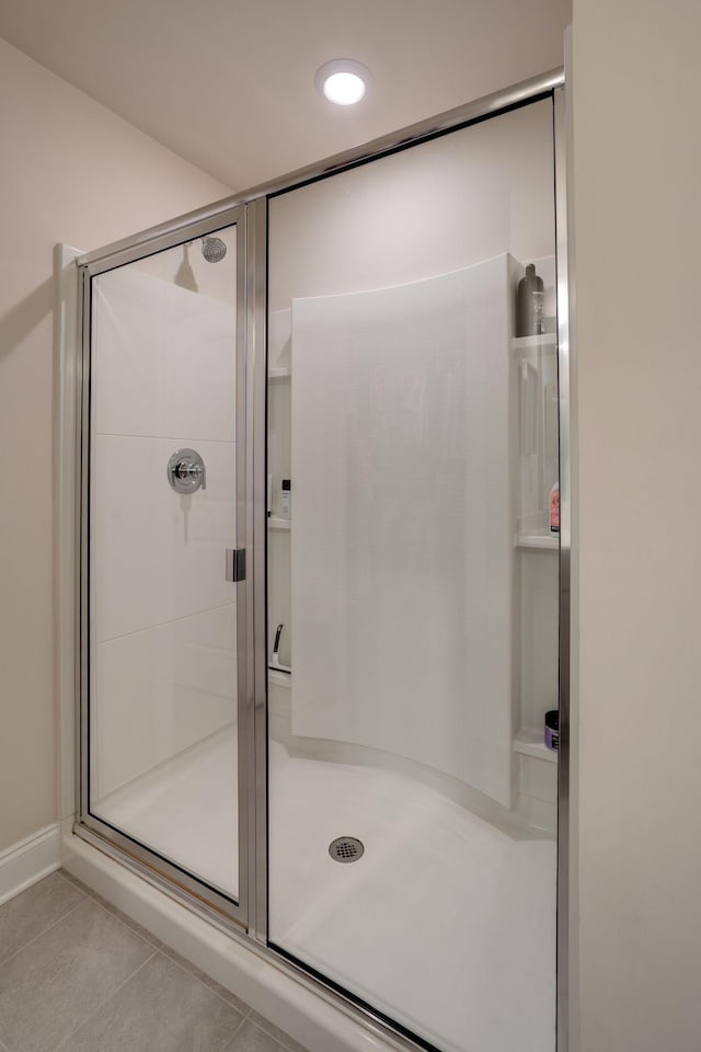 bathroom with tile patterned floors and a shower with door