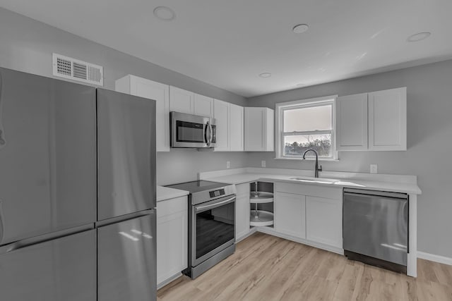 kitchen featuring white cabinetry, appliances with stainless steel finishes, sink, and light hardwood / wood-style floors