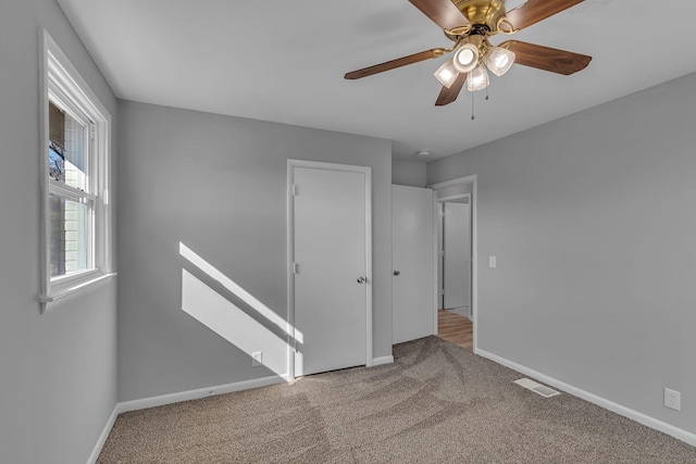 carpeted spare room featuring ceiling fan