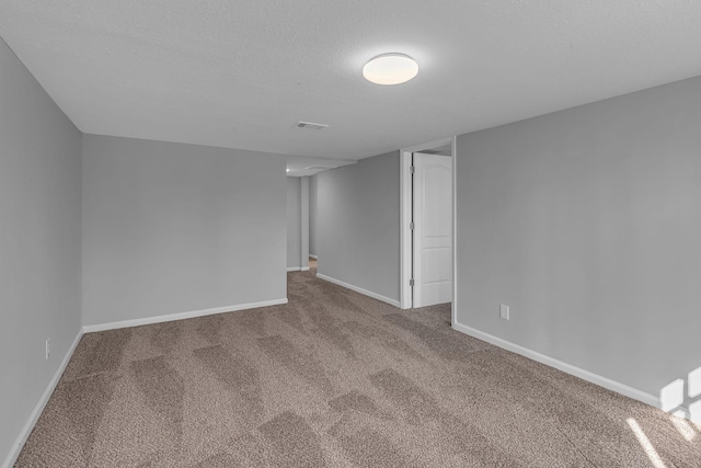 spare room featuring carpet flooring and a textured ceiling