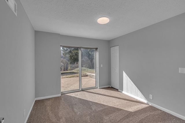 carpeted spare room featuring a textured ceiling