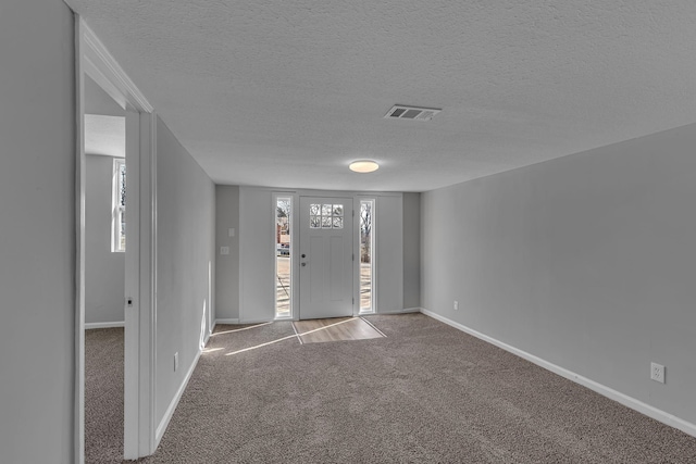 carpeted spare room featuring a textured ceiling