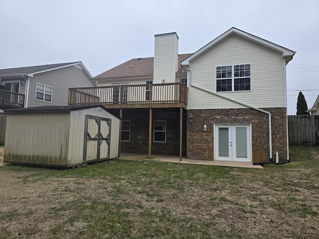 back of property featuring a shed, a lawn, french doors, and a deck