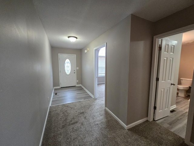 foyer featuring carpet flooring and a textured ceiling