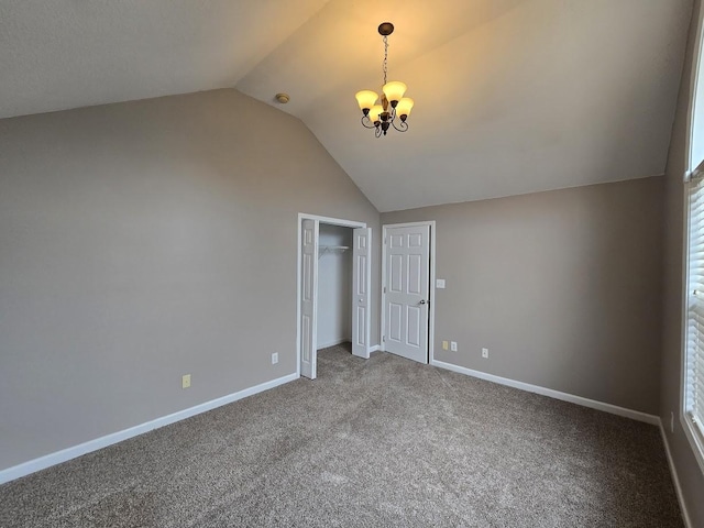 unfurnished bedroom featuring an inviting chandelier, lofted ceiling, carpet flooring, and a closet