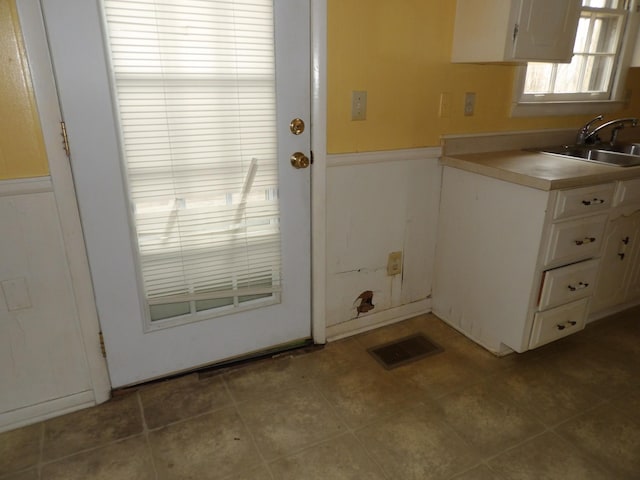 interior space with white cabinetry and sink