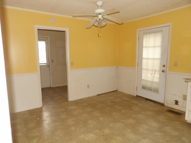 empty room featuring ornamental molding and ceiling fan