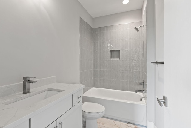 full bathroom featuring tiled shower / bath, vanity, and toilet