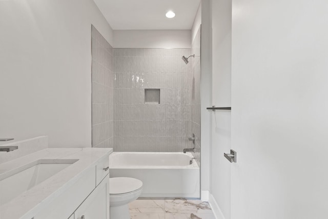 full bathroom featuring vanity, tiled shower / bath, and toilet