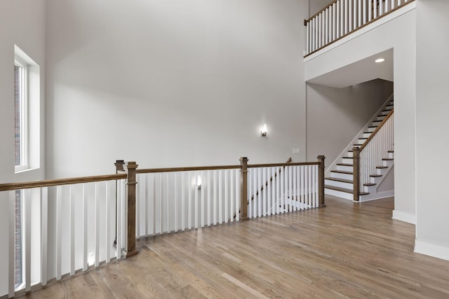 spare room featuring a towering ceiling and light hardwood / wood-style floors