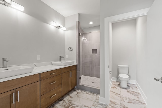 bathroom featuring toilet, vanity, and a shower with shower door