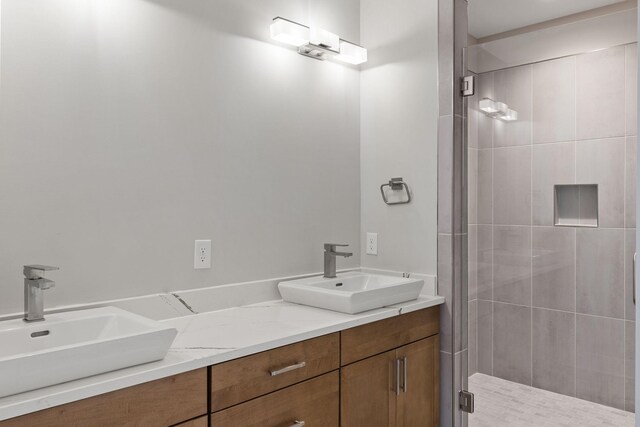 bathroom featuring a shower with door and vanity